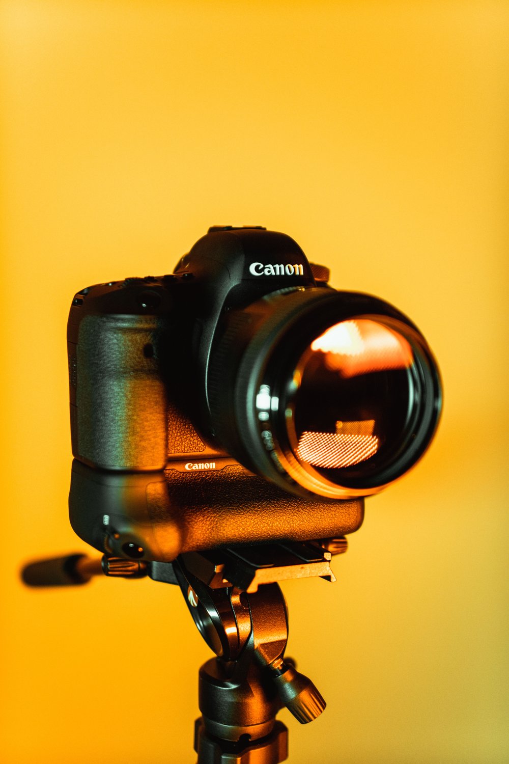 Camera on tripod with yellow background