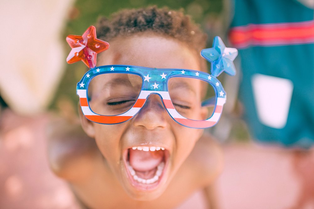 child with red, white and blue glasses