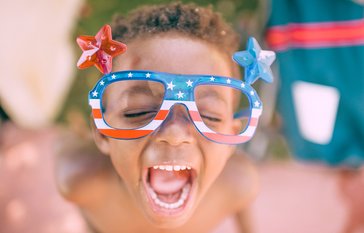 child with red, white and blue glasses